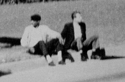 "Umbrella man" (right) sits on the curb after President Kennedy was shot in Dealey Plaza Dallas.